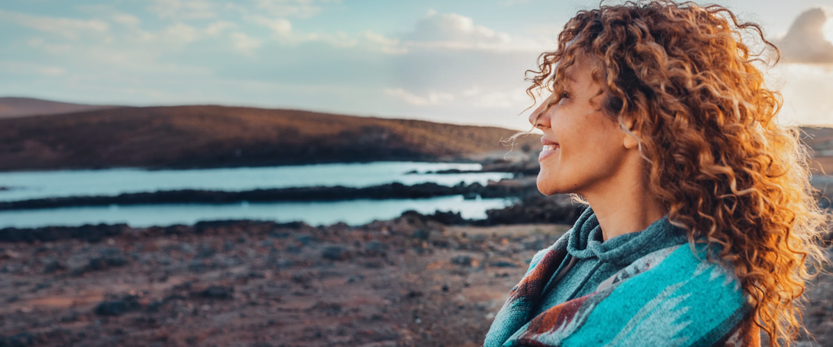 A woman standing outdoors in warm evening light